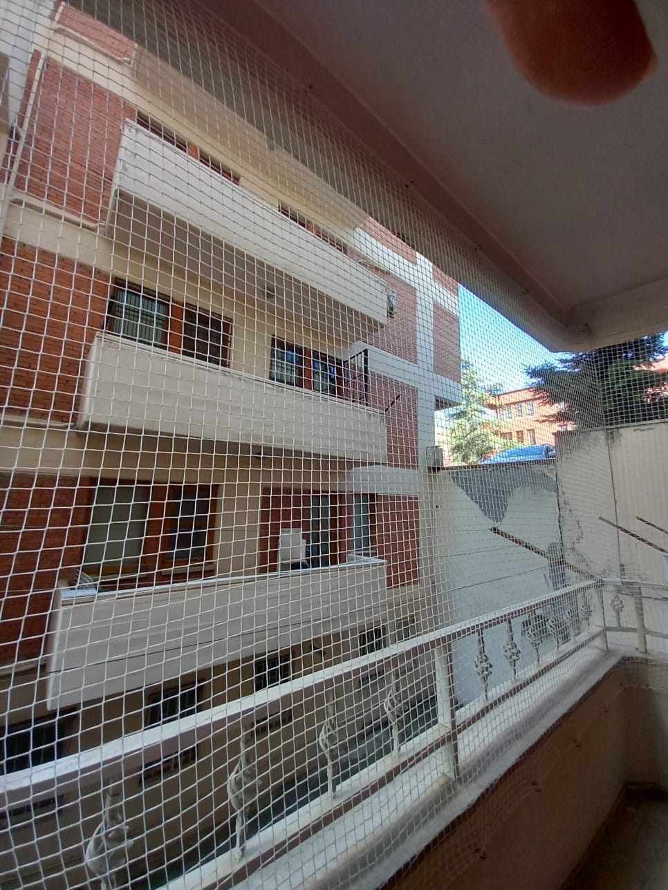 Balkon güvenlik filesinin yumuşak fırça ve suyla güvenli temizliği